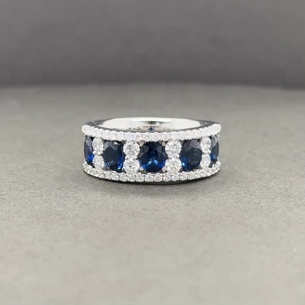 This ring has been made in 18k white gold and set with 5 oval cuts of natural sapphire, weighing 2.3cttw, and lined with round cuts of diamonds weighing 0.84cttw. These sapphires have hexagonal growth bands with broken needle inclusions. The diamonds are a G-H color, SI2-I1 clarity, have very good cut, good brightness, good pattern, very good fire, good polish, good symmetry, with moderate chalky blue fluorescence. This ring is a size 6.5, can be sized, has a 6mm shank, and weighs 7.45dwt.
