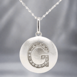 SS 0.05 H/SI1-SI2 Diamond "G" Initial Disk Pendant - Walter Bauman Jewelers